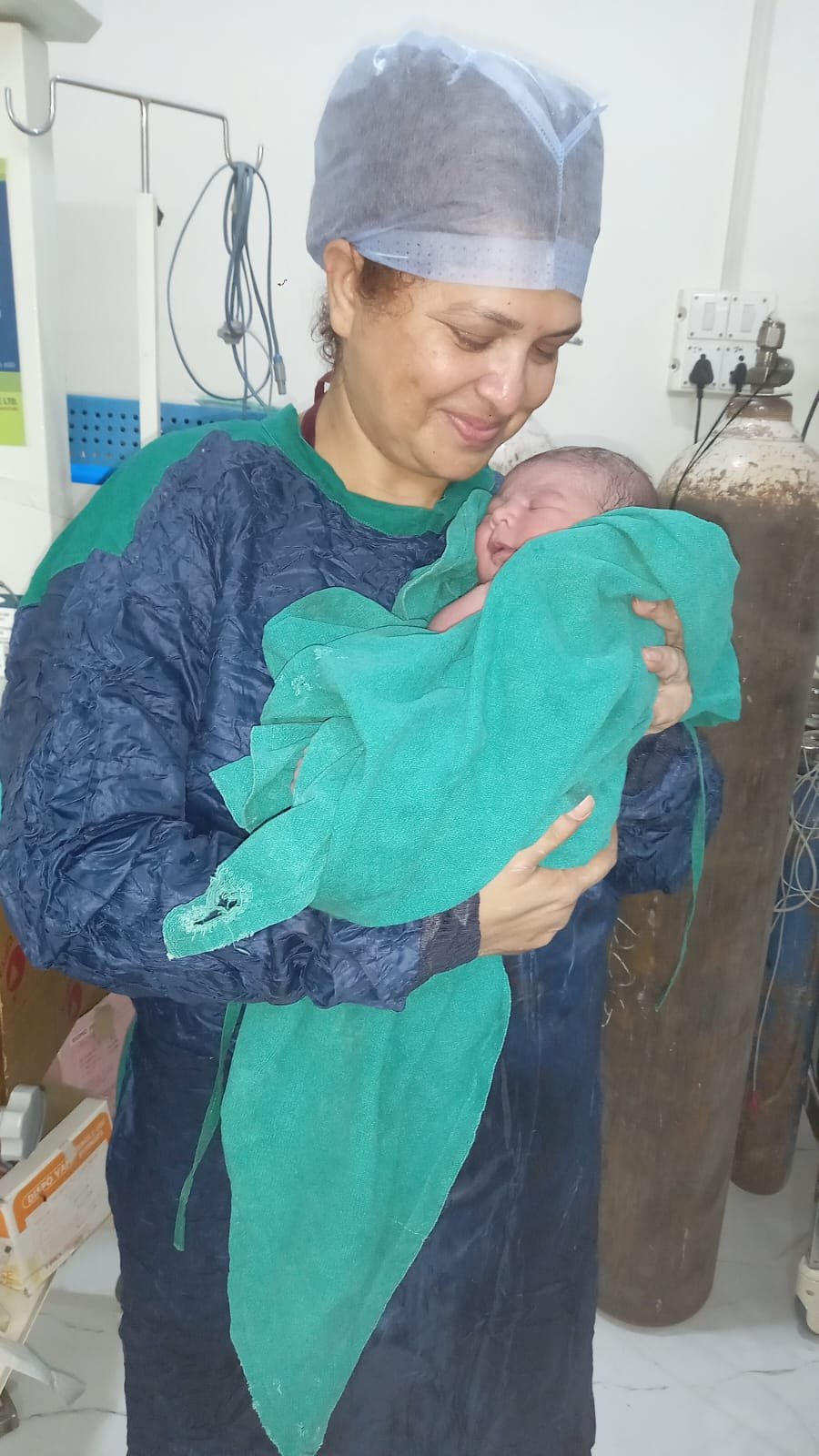 Newborn held by staff